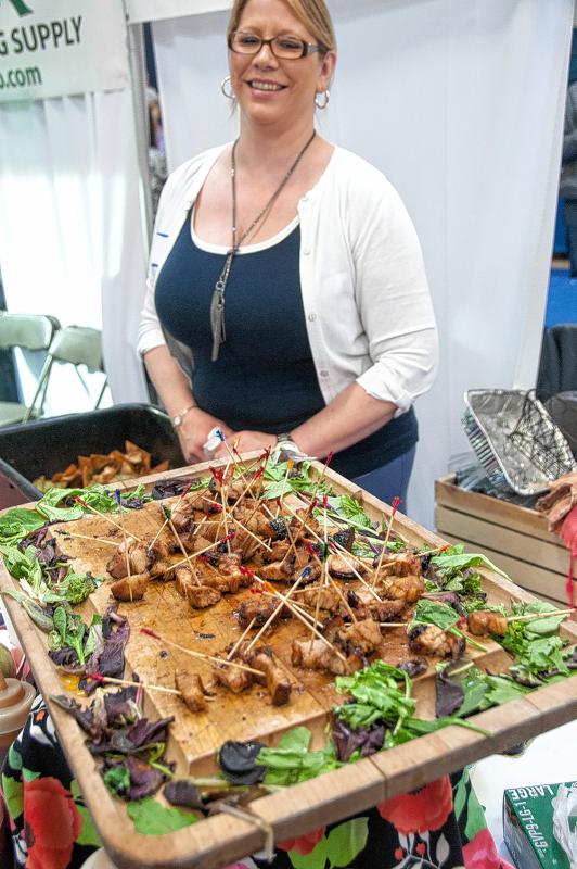 Lisa Billings, catering manager at Maple St. Catering and Big Fattys Pork Belly, looks over the dwindling plate of pork belly. The crown pleaser had folks coming back again and again for samples. The business is from White River Junction, Vt. (Medora Hebert photograph) - 