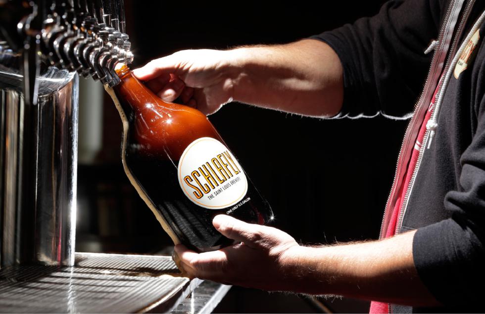 In this photo made Friday, March 27, 2015, an employee demonstrates for a photograph the pouring of a growler of beer at Schlafly Tap Room in St. Louis. A bill is moving through the Missouri Legislature that would allow the sale of jugs of beer, known as growlers, at convenience and grocery stores.  Currently the jugs, which are usually filled with craft brews so beer lovers can drink the fresh beverages at home, are only found at breweries and some bars. (AP Photo/Jeff Roberson) - Jeff Roberson | AP