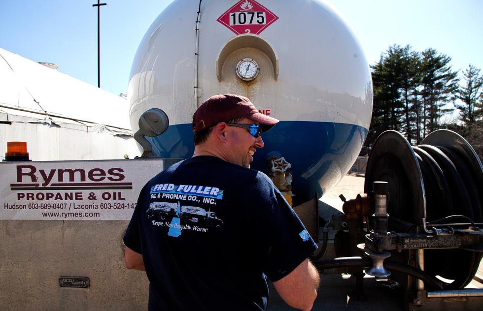 Rymes driver Armand Dion still wears his old Fred Fuller t-shirt as he fill up an old Fuller propane truck before heading back to Manchester this week. Dion likes working for Rymes and said the transition was smooth.  (GEOFF FORESTER / Monitor staff) - Concord Monitor
