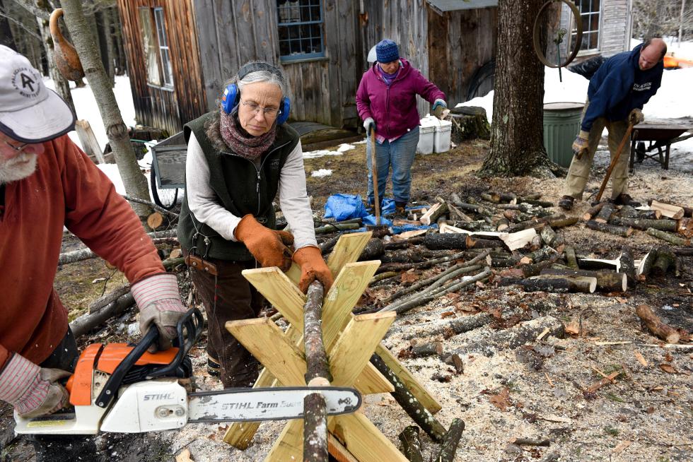From left, Stan McCumber, Jenny Wright, Vanessa Keith and Ian Ludders cut and split wood to help their neighbor Jim Romer, of Unity, get through the long heating season Friday, March 27, 2015. All five live on the Quaker City Land Trust, a cooperative community that shares resources. (Valley News - James M. Patterson) Copyright Â© Valley News. May not be reprinted or used online without permission. Send requests to permission@vnews.com. - James M. Patterson | Valley News