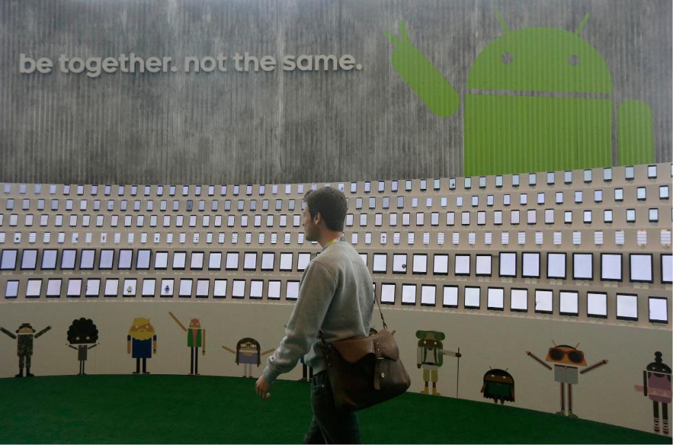 A man walks past a display of phones and mobile devices at Google I/O 2015 in San Francisco, Thursday, May 28, 2015. (AP Photo/Jeff Chiu) - Jeff Chiu | AP
