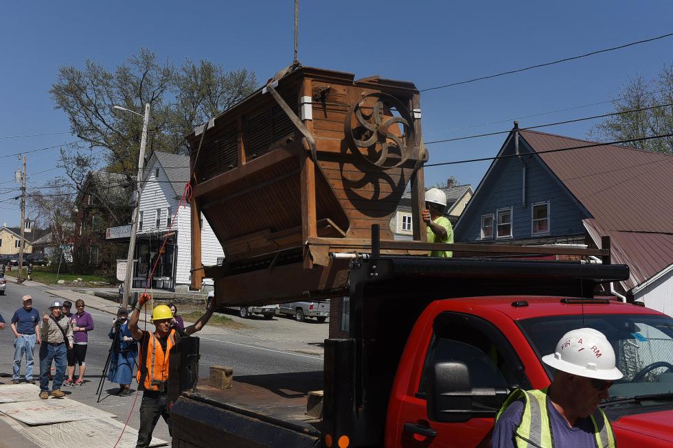 Pine Hill Construction workers gently guide a nearly 800 pound grain bolter onto the back of a truck after lifting it out of the basement of a condemned mill building on Pleasant Street in Claremont, N.H., on May 6, 2015. Gerry DeMuro, who bought the century-old piece of machinery, hopes to restore it to its former glory. (Valley News - Sarah Priestap) <p><i>Copyright © Valley News. May not be reprinted or used online without permission. Send requests to permission@vnews.com.</i></p> - Sarah Priestap | Valley News