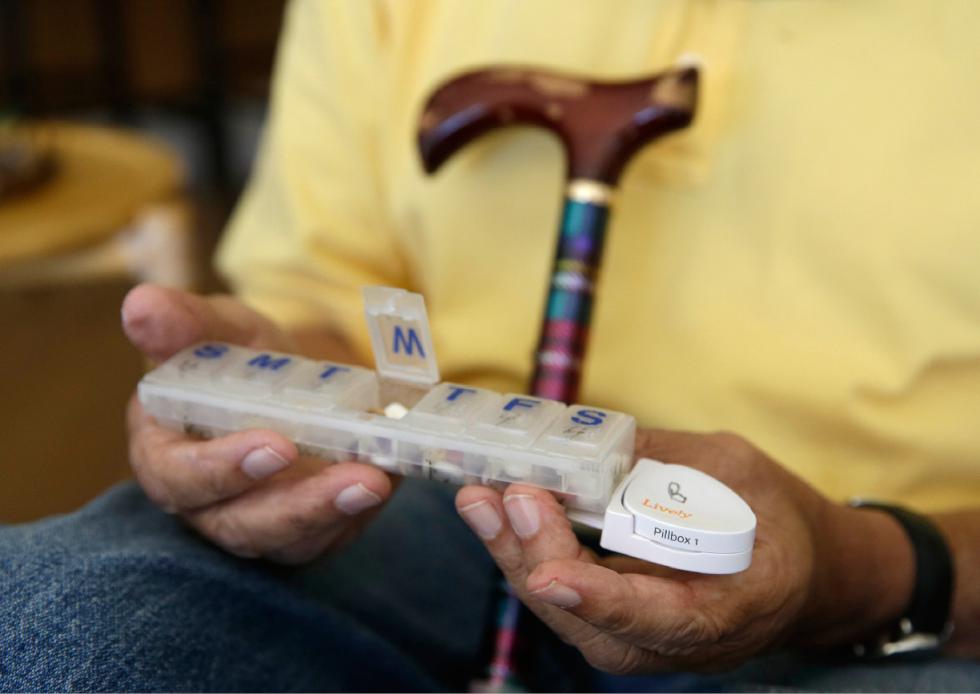 In this March 17, 2015 photo, 81-year-old Bill Dworsky holds his pill container with a motion sensor attached at his home in San Francisco. Each time Bill or his 80-year-old wife, Dorothy, opens the refrigerator, closes the bathroom door, or lifts the lid on a pill container, tiny sensors in their home make notes on a digital logbook, which their son Phil Dworsky monitors daily on his smartphone. (AP Photo/Eric Risberg) - Eric Risberg | AP