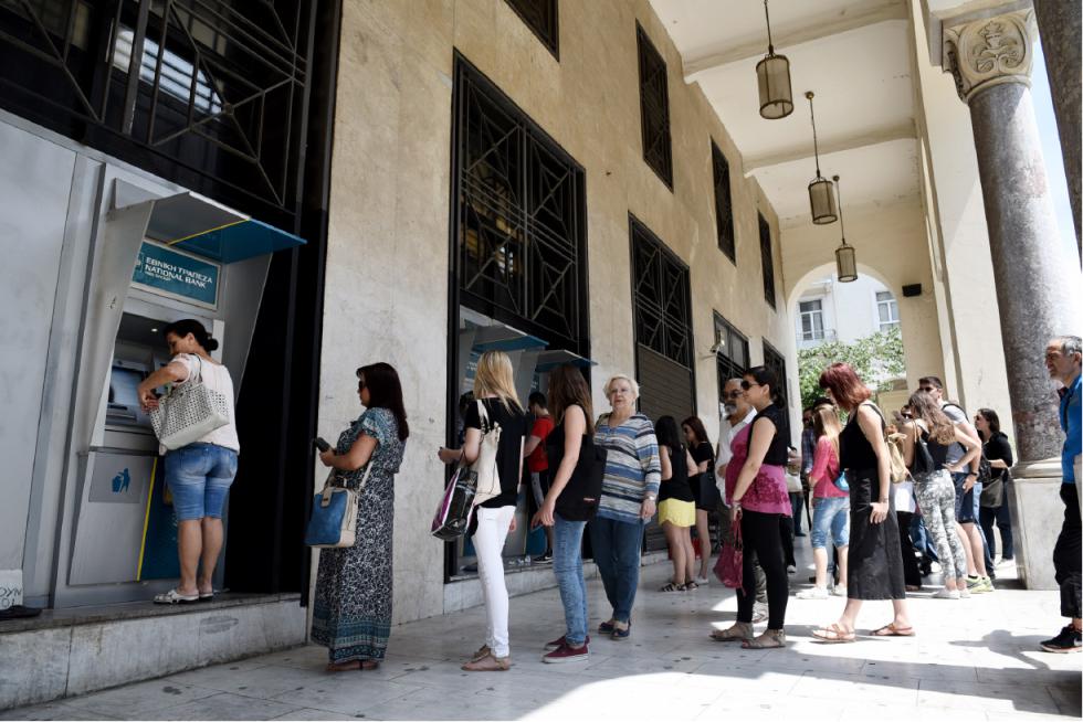 People stand in a queue to use the ATMs of a bank in the northern Greek city of Thessaloniki on Saturday, June 27, 2015. Greece's fraught bailout talks with its creditors took a dramatic turn early Saturday, with the radical left government announcing a referendum in just over a week on the latest proposed deal  and urging voters to reject it. (AP Photo/Giannis Papanikos) - Giannis Papanikos | AP