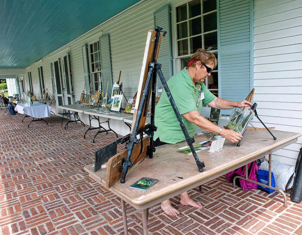 Sharon Allen of Derry sets up her work on the veranda during the annual artists weekend at The Fells in Newbury, N.H.  The artists display their work for the sale at the end of the day.  7-19-2015 Medora Hebert - 