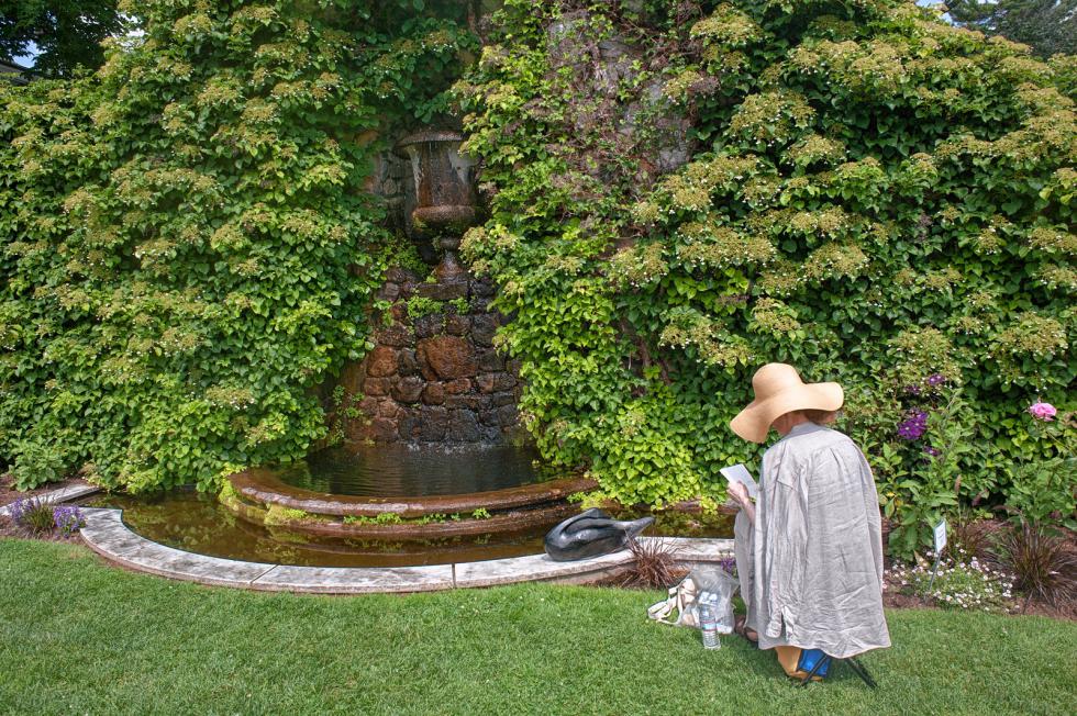 Elizabeth D'Amico of Springfield, NH sketches next to the fountain in the garden wall during the annual artists weekend at The Fells in Newbury, N.H.  7-19-2015  Medora Hebert -