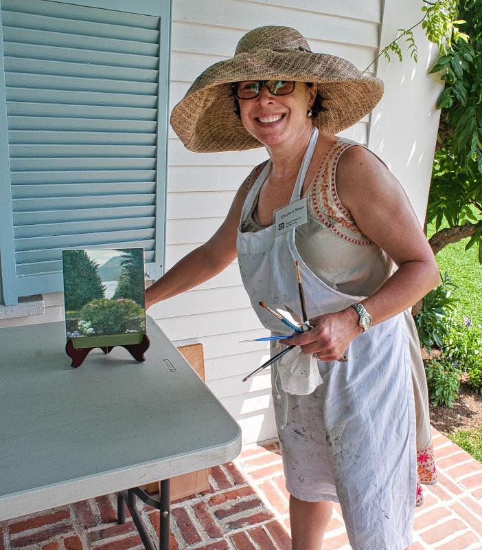 Elisabeth Slater of Claremont is all smiles as she places a finished and sold work on the display table of the veranda during the annual artists weekend at The Fells in Newbury, N.H.  7-19-2015 Medora Hebert -