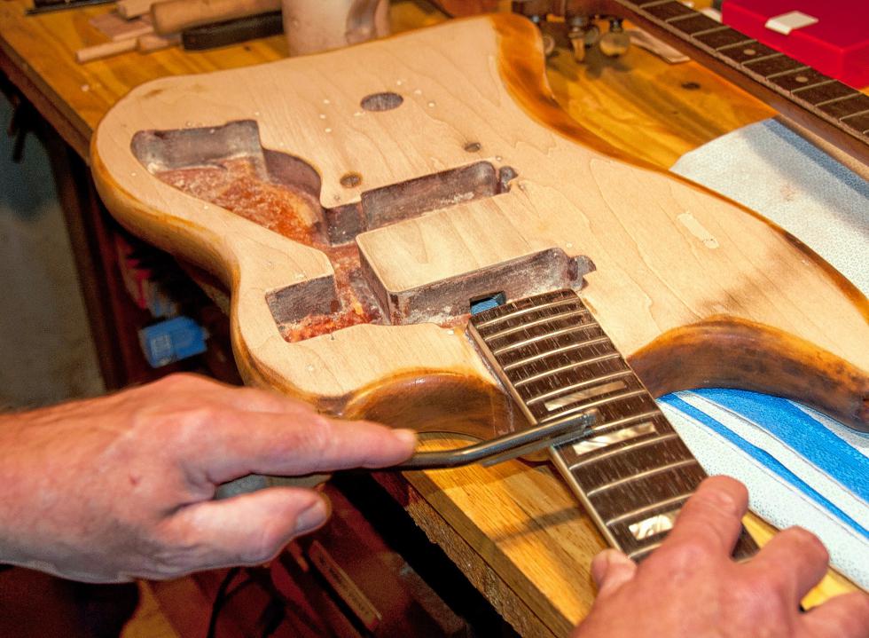 Will Morneault demonstrates a tool specifically made for the frets on guitars.  Medora Hebert photograph -