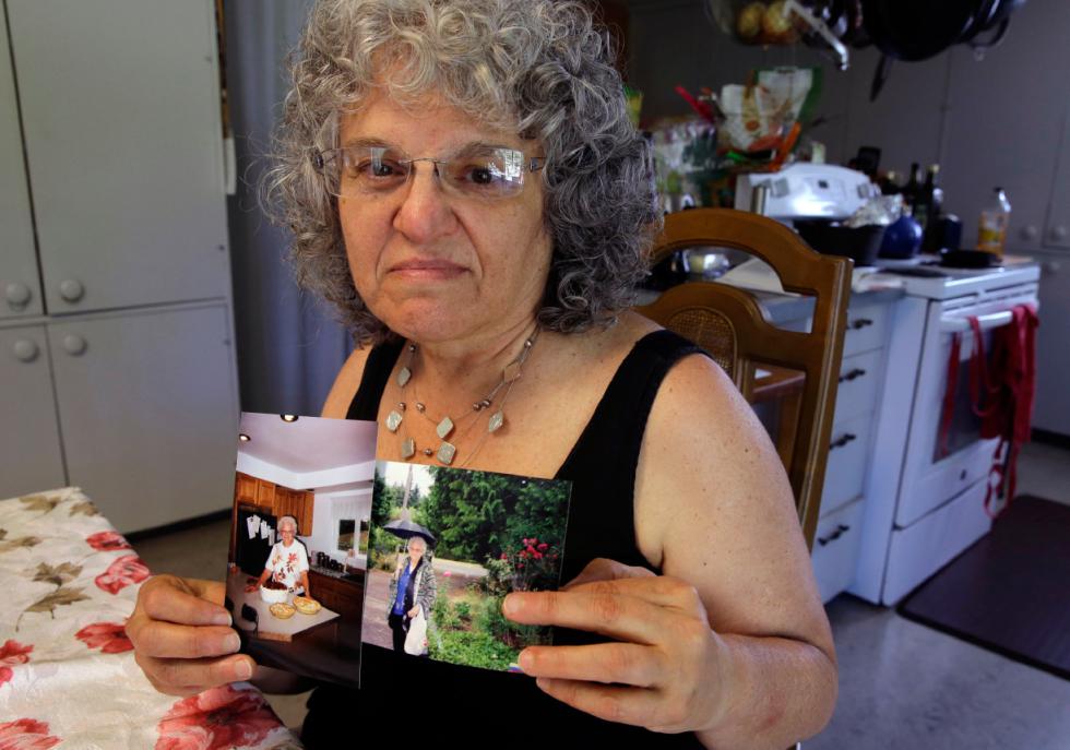 In this July 1, 2015 photo, Roslyn Duffy poses for a photo holding two photos of her late mother, Evelyn Nappa, at her home in Seattle. Duffy had to scramble to find a home willing to take Medicaid payments after her mother was evicted from a Seattle assisted-living facility. The stress and the change of surroundings strained her mother's health, Duffy said, and six weeks after moving, she was dead. (AP Photo/Ted S. Warren) - Ted S. Warren | AP