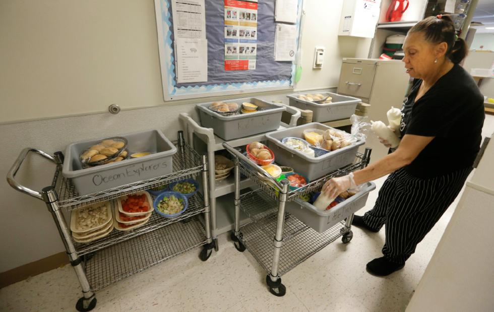 Chef Patricia Worrell loads carts with lunch for daycare students at the Olathe Family YMCA in Olathe, Kan., Wednesday, June 24, 2015. Worrell is a chef for Bistro Kids. (AP Photo/Orlin Wagner) - Orlin Wagner | AP