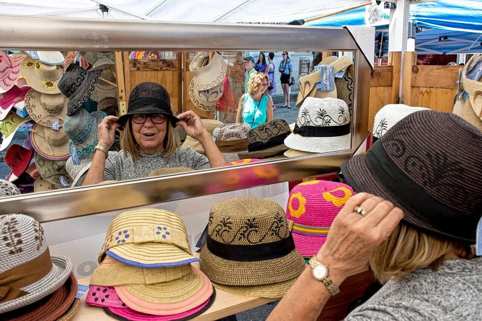 Nancy Normandeau tries on a hat by Mountain Tops of Waitsfield, Vt., at The Taste of Woodstock festival on Aug. 8. Nancy Nutile-McMenemy photograph -