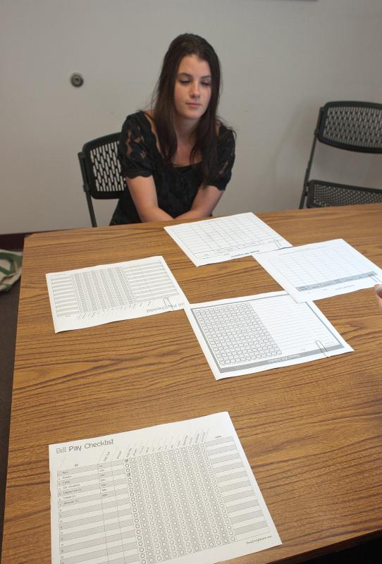 Katie Emery of Lebanon works on her finances with Megan Sather.  8-12-2015 MEdora HEbert - 