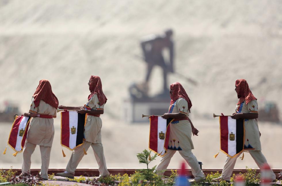 Egyptians wear Pharaonic costumes as they march in front of a statue representing a man digging the new section of the Suez Canal in Ismailia, Egypt, Thursday, Aug. 6, 2015. With much pomp and fanfare, Egypt on Thursday unveiled a major extension of the Suez Canal whose patron, President Abdel-Fattah el-Sissi, has billed as an historic achievement needed to boost the countrys ailing economy after years of unrest.  (AP Photo/Hassan Ammar) - Hassan Ammar | AP