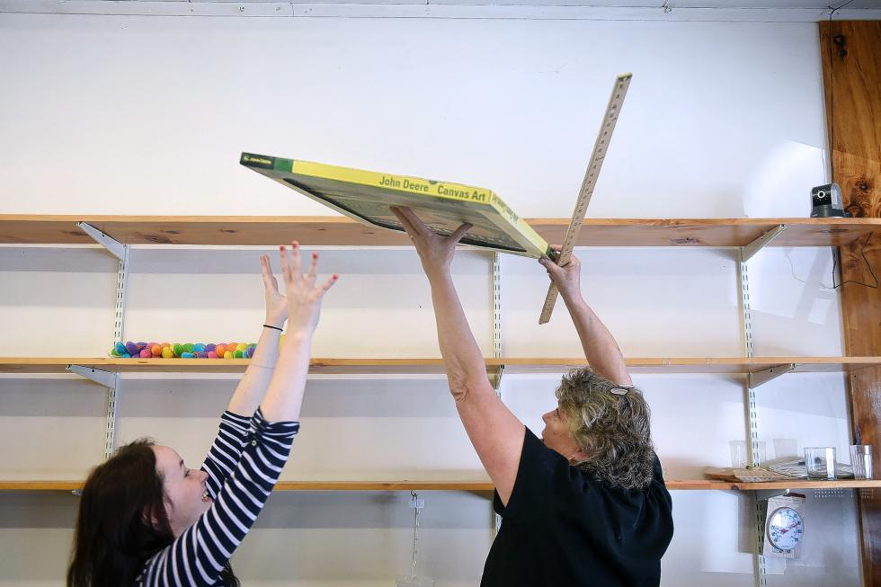 Sandra McCool, left, helps Hill's 5 & 10 owner Mary Wendell move an item for a customer at the store in Bradford, Vt., on August 14, 2015. Shelves are quickly clearing as faithful customers pour into the store to shop at a long-time mainstay of Bradford that is closing at the end of August.  (Valley News - Sarah Priestap) <p><i>Copyright © Valley News. May not be reprinted or used online without permission. Send requests to permission@vnews.com.</i></p> - Sarah Priestap | Valley News