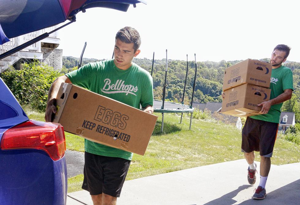 Rob Torres, left, a student at the University of Pittsburgh, and Dimitrije Slavkovic, a Carnegie Mellon University student - both Bellhops employees - carry boxes to help move the Bayer family to their new home on July 30, 2015 in McMurray, Pa. (Darrell Sapp/Pittsburgh Post-Gazette/TNS) - Darrell Sapp | Pittsburgh Post-Gazette