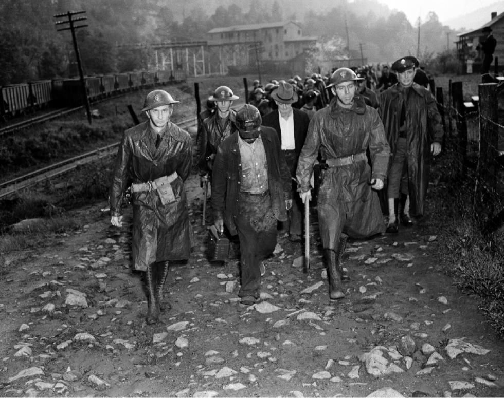 FILE - In this May 16, 1939 file photo, their day's work done, miners who reported for duty for the Harlan Central Coal Company near Harlan, Ky., leave the mine under the guard of troops who escorted them through a picket line. The union era's death knell sounded in Kentucky on Dec. 31, 2014, when Patriot Coal announced the closing of its Highland Mine. (AP Photo/Preston Stroup, File) - Preston Stroup | AP