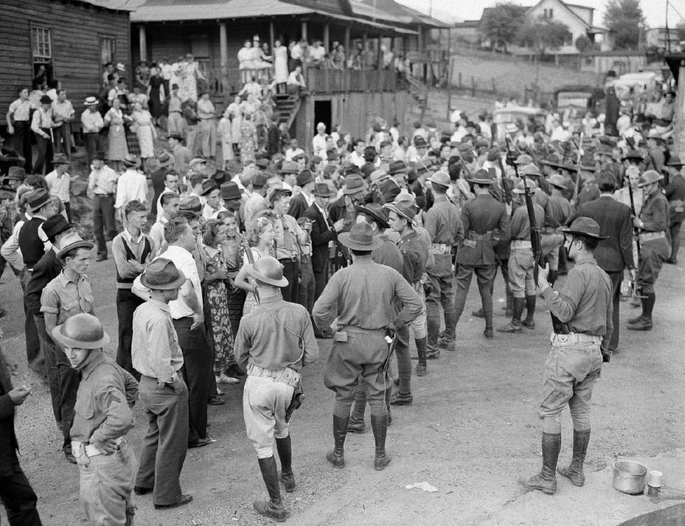 FILE - In this May 19, 1939 file photo, striking union members are guarded by National Guardsmen at the entrance of Harlin-Wallins Coal Corp. property at Verda, in Harlan County, Ky. Kentucky coal miners bled and died to unionize. Their workplaces became war zones, and gun battles once punctuated union protests. The union era's death knell sounded in Kentucky on Dec. 31, 2014, when Patriot Coal announced the closing of its Highland Mine. (AP Photo/File) - AP