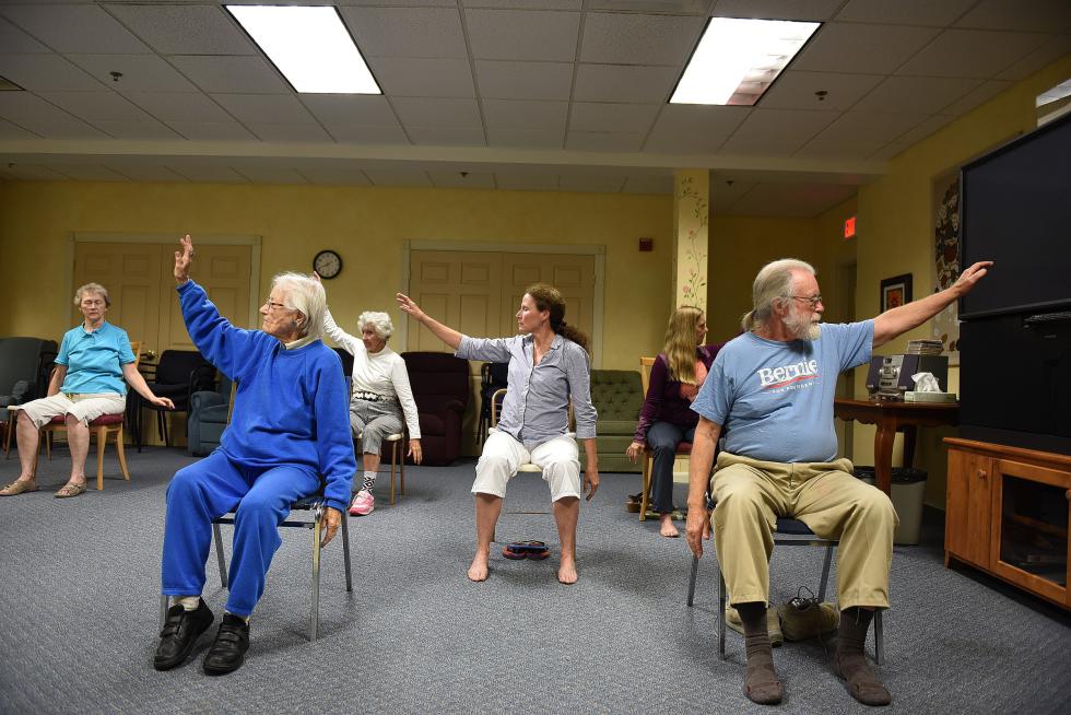 Jane Hammond,left,  and her son Lee Hammond participate in a chair Tai Chi class at Harvest Hill in Lebanon, N.H. on Sept. 11, 2015. Jane Hammond, 104, was the first person to move into Harvest Hill 20 years ago.(Valley News - Jennifer Hauck) <p><i>Copyright © Valley News. May not be reprinted or used online without permission. Send requests to permission@vnews.com.</i></p> - Jennifer Hauck | Valley News