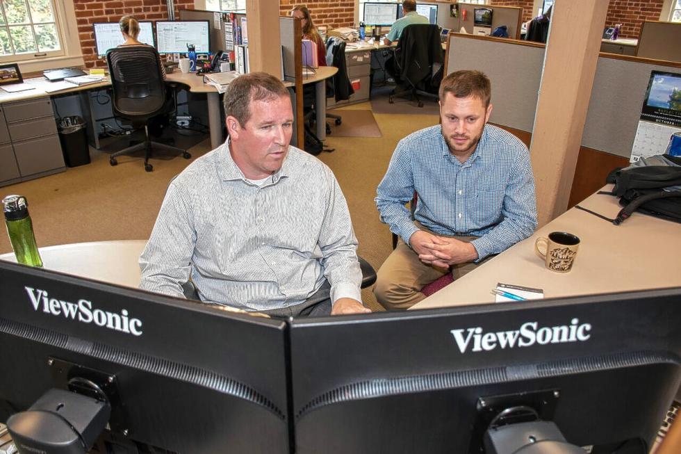 Steve Bourque, of Sunapee, N.H., and Ethan Brown, of Weathersfield, Vt., work together on a sales spreadsheet on Oct. 13, 2015, at Red River Computer Co. in Claremont, N.H. (Nancy Nutile-McMenemy photograph) -