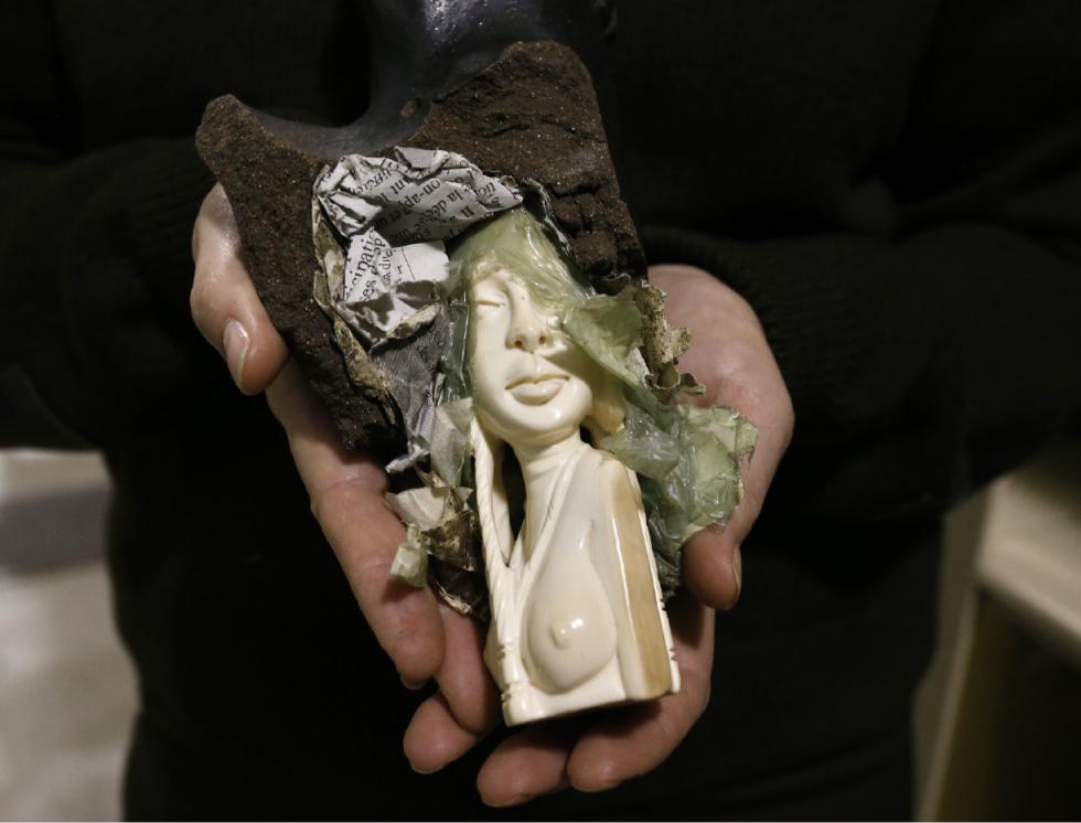In this Oct. 20, 2015 photo, supervising wildlife repository specialist Coleen Schaefer holds a seized ivory carving which smugglers tried to conceal inside pottery, inside a warehouse at the U.S. Fish and Wildlife Service's National Wildlife Property Repository in Commerce City, Colo. More than 20,000 elephants are being killed annually despite some progress in anti-poaching efforts and the increasing awareness of governments, according to Lamine Sebogo, a representative from the World Wildlife Fund in March 2013. (AP Photo/Brennan Linsley) - Brennan Linsley | AP