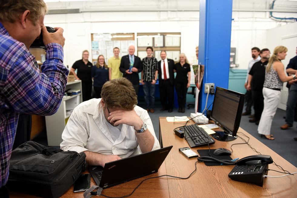 Robert Weeks of All-Access Infotech works through a media event at Seldon Technologies in Windsor, Vt., on July 1, 2015.  Weeks does IT work at the company, maintaining their servers. Behind him U.S. Sen. Patrick Leahy, D-Vt., has his photgraph taken with Seldon employees (Valley News - Jennifer Hauck) <p><i>Copyright © Valley News. May not be reprinted or used online without permission. Send requests to permission@vnews.com.</i></p> - Jennifer Hauck | Valley News