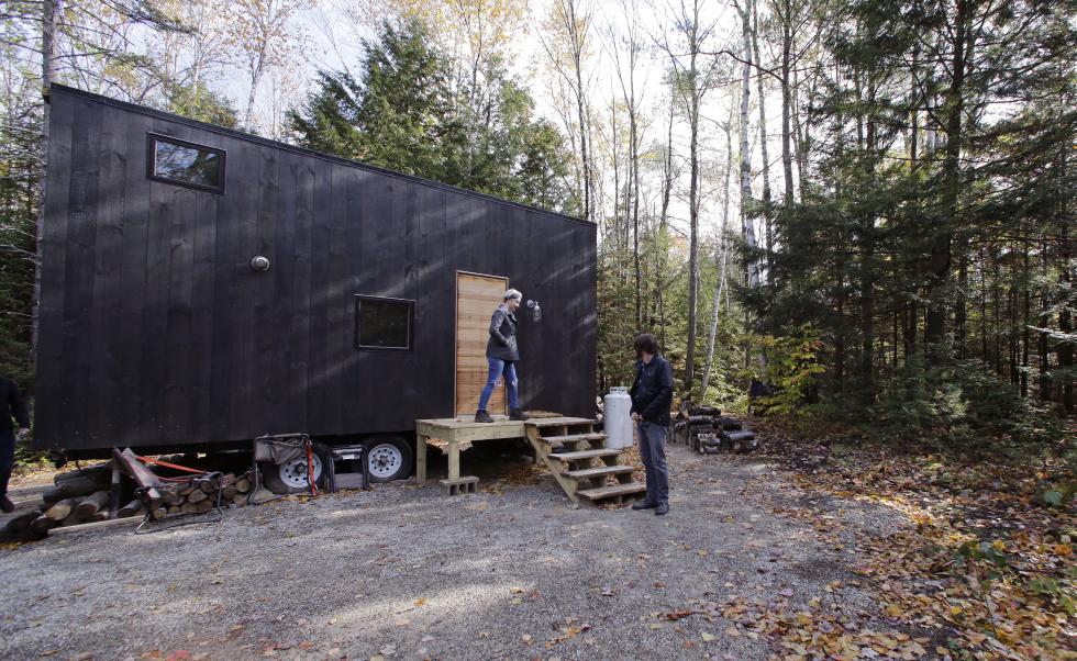 In this Tuesday, Oct. 20, 2015 photo, Hilary Lentz, of Pittsburgh, Pa., and her husband Shane leave the tiny house which they rented for a weekend in Croydon, N.H. As the tiny house phenomenon sweeps the nation, Harvard's Millennial Housing Lab thinks a tryout is in order for people toying with radically downsizing their lives. Its new "Getaway" project gives the curious an opportunity to spend a night or two in one of three tiny houses and get a real feel for the lifestyle before taking the plunge. (AP Photo/Charles Krupa) - Charles Krupa | AP