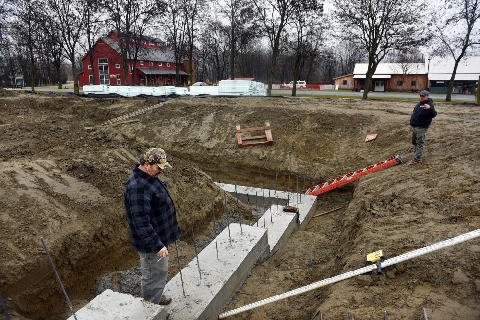 Barry Metcalf, a job foreman with Osgood Construction in Claremont, N.H., discusses the foundation of a new building for Blake Hill at Artisans Park in Windsor, Vt., with fellow job foreman Mike West on Dec. 23. 2015.   (Valley News - Sarah Priestap) <p><i>Copyright © Valley News. May not be reprinted or used online without permission. Send requests to permission@vnews.com.</i></p> - Sarah Priestap | Valley News