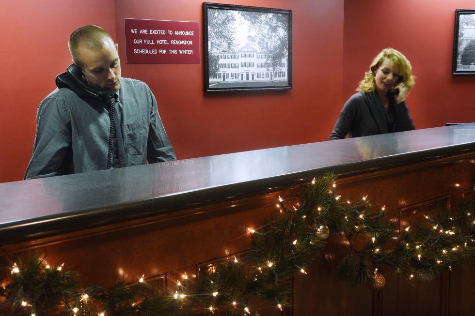 Front desk associate Mike Smith, left, and general manager Libby Cole schedule reservations at the Residence Inn on Centerra Parkway in Lebanon, N.H., on Dec. 4, 2015. Behind them, a sign announces the hotel's upcoming renovation. (Valley News - Sarah Priestap) Copyright © Valley News. May not be reprinted or used online without permission. Send requests to permission@vnews.com. - Sarah Priestap | Valley News