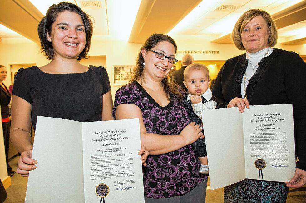 Medical assistant graduate Cassie Audette, of Lebanon, center, and her son James, at the Nov. 5, 2015, ceremony while Nicole Laware, left, a pharmacy  technologist graduate, and Sarah Currier, director of workforce development, hold proclamations from New Hampshire Gov. Maggie Hassan marking Women in Apprenticeship Day and National Apprenticeship Week. Audette was 12 weeks pregnant on the first day of her medical assistant program class. Nancy Nutile-McMenemy photograph - 