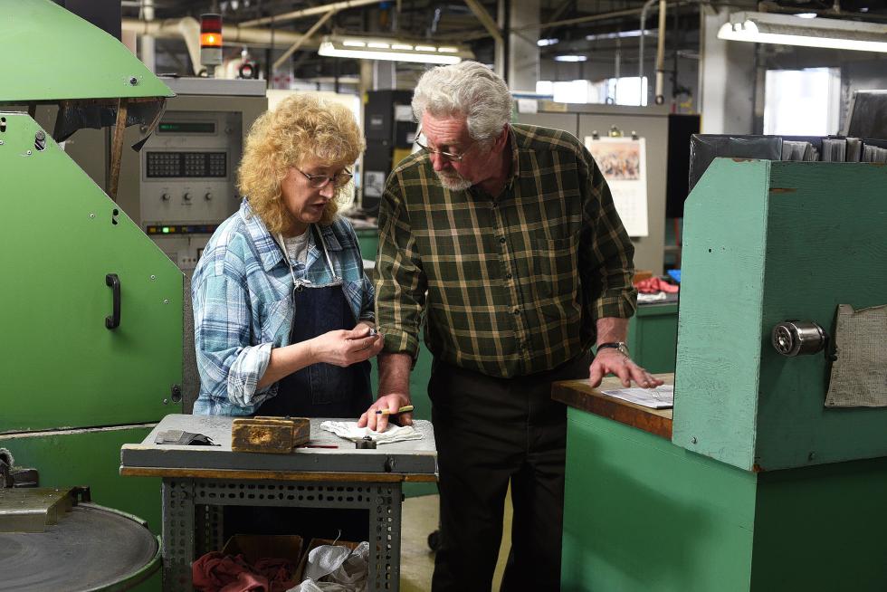 Warren Garfield, plant manager at Lovejoy Tool Company, checks in with machinist Penny Jenkins as she grinds cutting tool inserts at the Springfield, Vt. manufacturer Wednesday, January 20, 2016. Garfield has worked for Lovejoy for 50 years, half of its 100 year history, starting as a part time machinist 1965, moving on to a sales position after graduating from college, and becoming plant manager in 1978. (Valley News - James M. Patterson) <p><i>Copyright Â© Valley News. May not be reprinted or used online without permission. Send requests to permission@vnews.com.</i></p> - James M. Patterson | Valley News