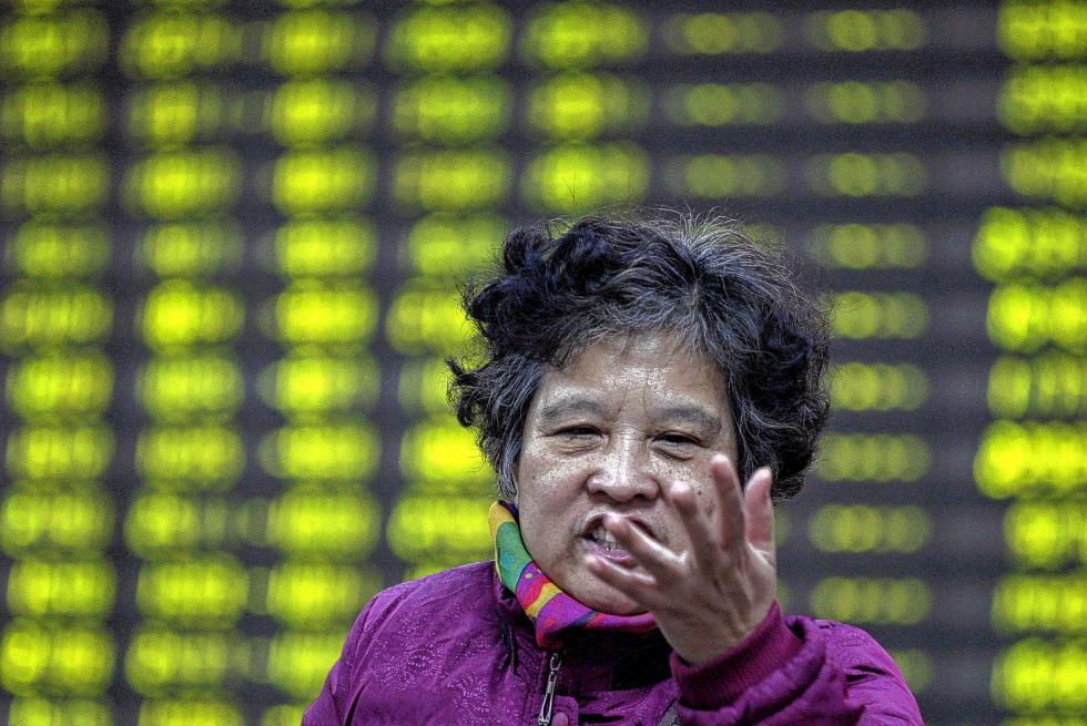 A Chinese investor gestures near a stock price display board at a brokerage in Huaibei in China's Anhui province Monday, Jan. 4, 2016. China's Shanghai stock index plunged nearly 7 percent on Monday and trading in Chinese shares was halted for the remainder of the day after weak manufacturing data and Middle East tensions weighed on Asian markets.  (Color China Photo via AP) CHINA OUT - COLOR CHINA PHOTO