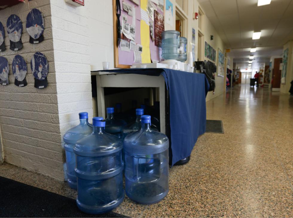 In this Thursday, Jan. 21, 2016 photo, bottles of drinking water are seen in a hallway at St. Mary's Academy in Hoosick Falls, N.Y. Federal regulators have warned residents of the upstate New York factory village near the Vermont border not to drink water from municipal wells, and a plastics plant has agreed to supply bottled water and pay for a new filtration system. (AP Photo/Mike Groll) - Mike Groll | AP
