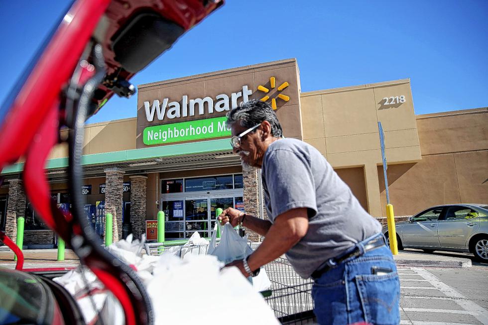 Richard Gutierrez loads groceries after shopping with his mother, Juanita Gutierrez, at the Wal-Mart Neighborhood Market in Dallas, Friday, Jan. 15, 2016. The Bentonville, Ark., company announced Friday the planned closure of 269 stores, more than half of them in the U.S. and another big chunk in its challenging Brazilian market. (Andy Jacobsohn/The Dallas Morning News via AP) MANDATORY CREDIT; MAGS OUT; TV OUT; INTERNET USE BY AP MEMBERS ONLY; NO SALES - Andy Jacobsohn | The Dallas Morning News