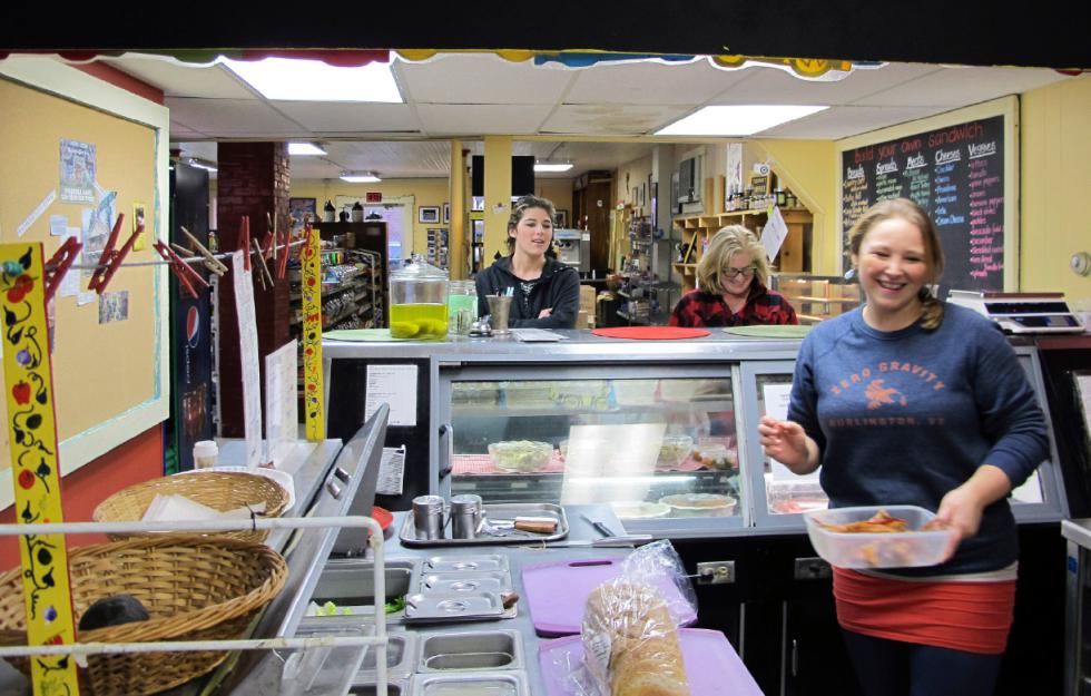 In this Dec. 18, 2015 photo, Becca Turner, right, works in the deli as Shanely and Catherine Tarrant await their order at the Underhill Country Store in Underhill, Vt. The 130-year-old store, a community hub, was at risk of closing after the owners decided to retire but had trouble selling it. The community rallied, raising just over $39,000 in four days to save the store. (AP Photo/Lisa Rathke) - Lisa Rathke | AP