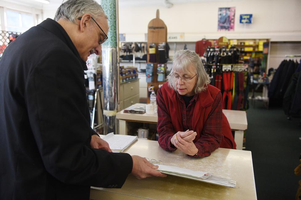 Ed Hirsch, owner of Hirsch's Clothing in Lebanon, N.H., consults with long-time employee Sandra Morancy about a custom order while the two worked to organize the store and fill orders on Jan. 7, 2015. Hirsch is the third generation of family to own and manage the clothing store.  (Valley News - Sarah Priestap) Copyright © Valley News. May not be reprinted or used online without permission. Send requests to permission@vnews.com. - Sarah Priestap | Valley News