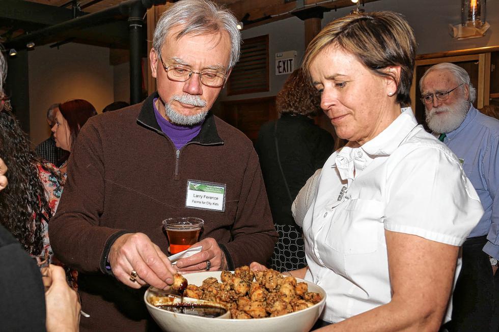 Larry Ference, of Farms for City Kids in Reading, Vt., samples the food served by LIsa Weiss of Simon Pearce at the Chamber-to-Chamber mixer on Feb. 10 at Simon Pearce in Quechee, hosted by the Woodstock Area Chamber of Commerce and the Hartford Area Chamber of Commerce. (Gloria Towne photograph/allaroundtowne.com) - gloria towne |