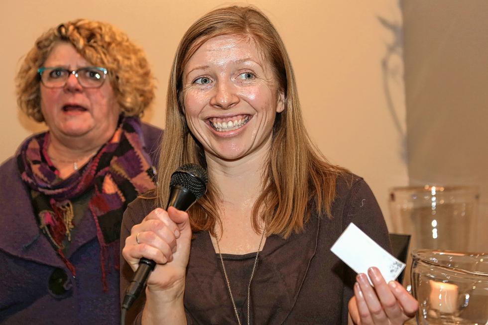 Simon Pearce marketing director Meghan Mahoney pulls a business card during the raffle at the Chamber-to-Chamber mixer on Feb. 10 at Simon Pearce in Quechee, hosted by the Woodstock Area Chamber of Commerce and the Hartford Area Chamber of Commerce. Beth Finlayson, director of the Woodstock Chamber, is at left. (Gloria Towne photograph/allaroundtowne.com) - Gloria Towne |