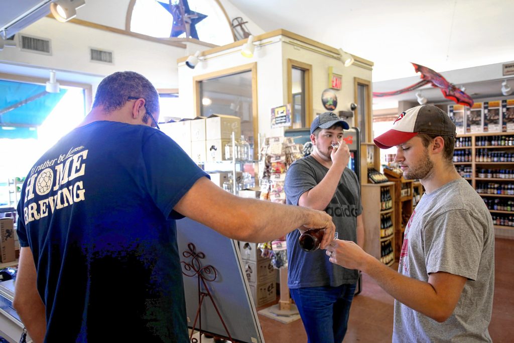 Wine specialist Jason Landers offers samples of Lagunitas Brewing Company's beer for Aaron McDowell, of Lebanon, N.H., right, and Tyler Swanson, of Rockford, Ill., during the weekly tastings held at the Lebanon Brew Shop in Lebanon, N.H., on September 16, 2016. The friends said they like trying different varieties of beer but are not home brewers. (Valley News - Geoff Hansen) Copyright Valley News. May not be reprinted or used online without permission. Send requests to permission@vnews.com.