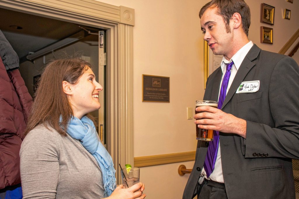 Markell Ripps, left, board chair of the Upper Valley Young Professionals, speaks with Noah Detzer about a podcast project about young professionals at the group's holiday party and canned food drive at the Norwich Inn on Dec. 15. (Nancy Nutile-McMenemy photograph, photosbynanci@comcast.net)