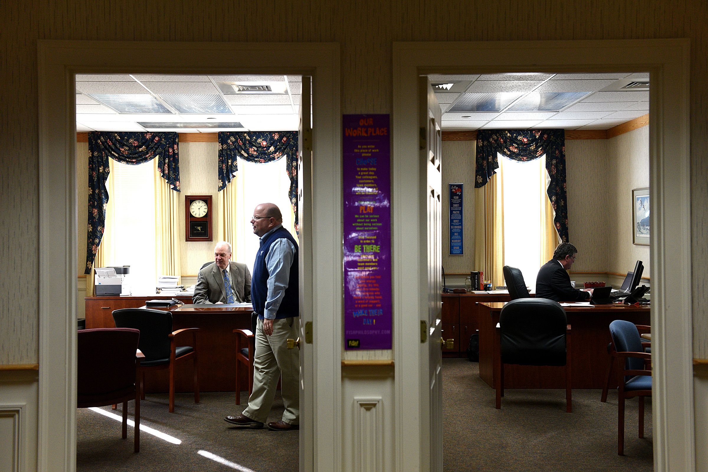 William McIver, who is now regional vice president for Lake Sunapee Bank, left, speaks with Tyler Gilday, senior vice president and director of retail lending, in McIver’s office in Newport. At far right is outgoing CEO Stephen Theroux.