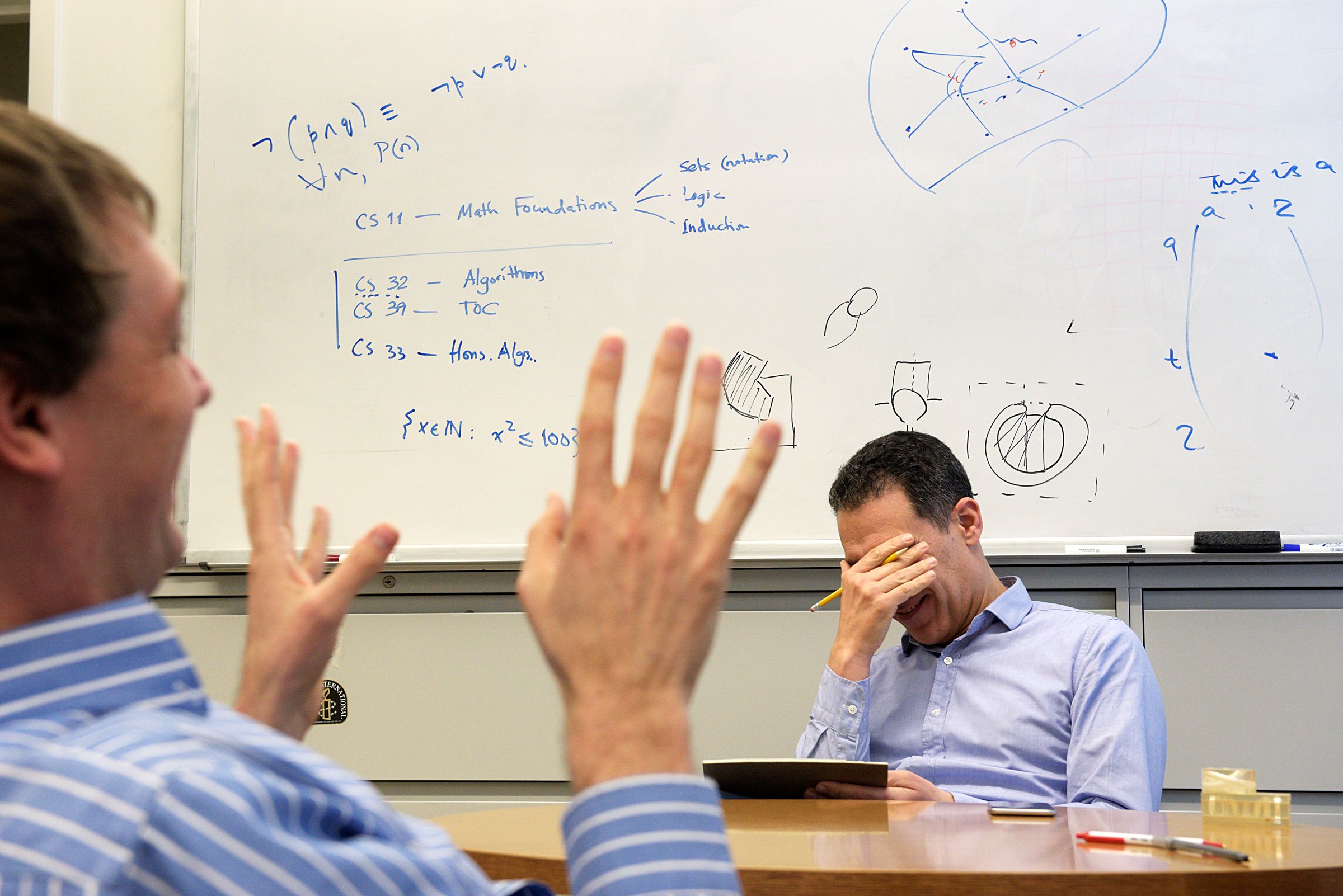 Hany Farid, of Norwich, laughs with associate professor of computer science Devin Balkcom while planning a course for Tuck business school students in Hanover, N.H., Wednesday, February 15, 2017. (Valley News - James M. Patterson) Copyright Valley News. May not be reprinted or used online without permission. Send requests to permission@vnews.com.