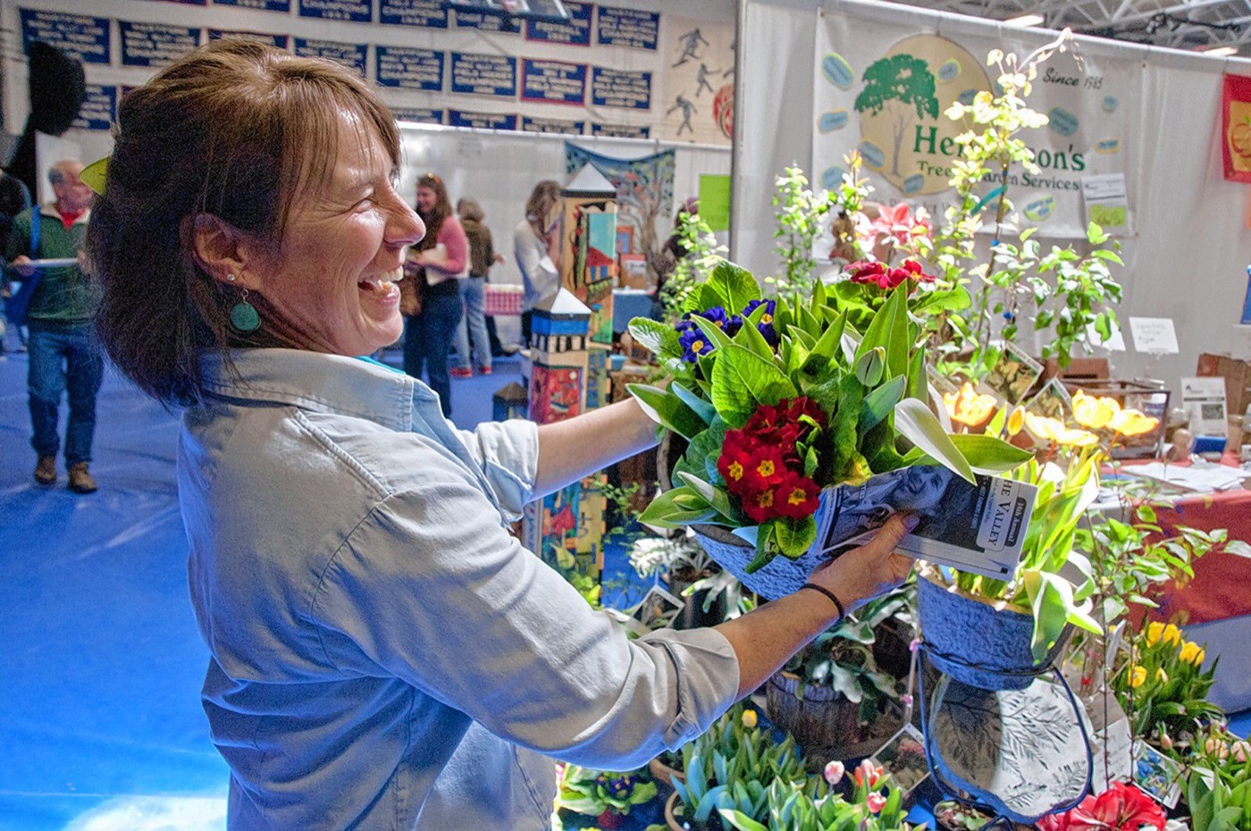 ( A COLORFUL DISPLAY Sylvia Provost, owner of Henderson’s Tree & Garden Services in White River Junction, shows off some spring flowers at the 2015 Flavors of the Valley event.