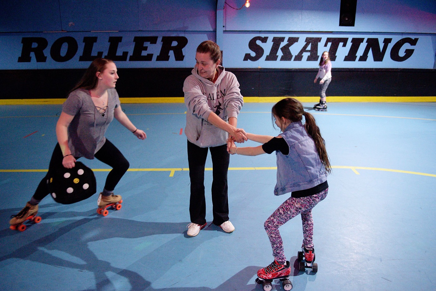 Gayl Pringle, manager of Great View, swings her granddaughter Cadence Rullo, of Enfield, in a circle as Bella Harty, 13, of Unity, left, skates around them in Enfield, N.H., Friday, March 17, 2017. "I love this place," said Harty. "It's my happiness." (Valley News - James M. Patterson) Copyright Valley News. May not be reprinted or used online without permission. Send requests to permission@vnews.com.