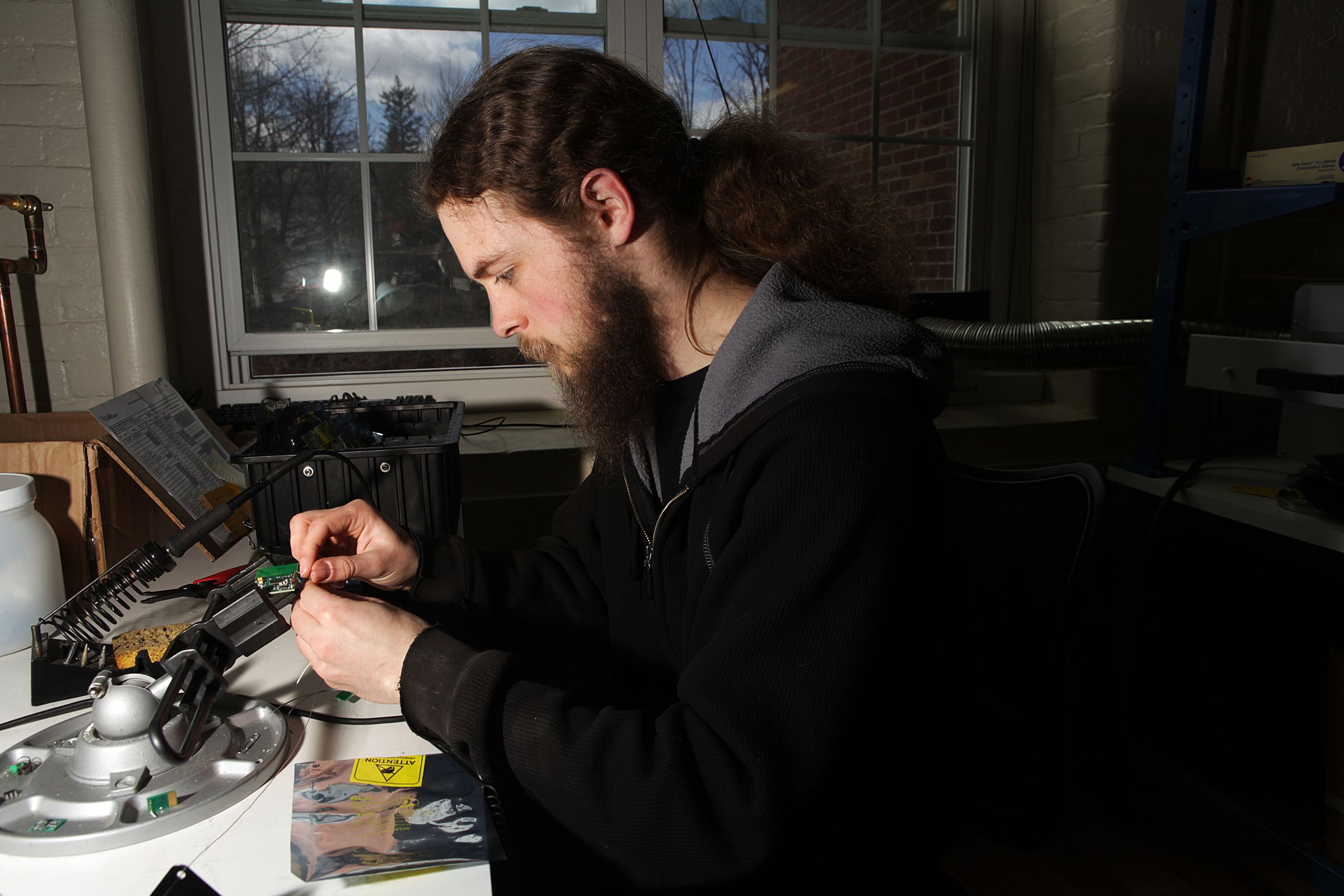 Nick Conquest, an electrical engineer and technician at Simbex, tests old prototypes of the company's head impact technology measuring system on Thursday, April 13, 2017, in Lebanon, N.H. (Valley News - Jovelle Tamayo) Copyright Valley News. May not be reprinted or used online without permission. Send requests to permission@vnews.com.