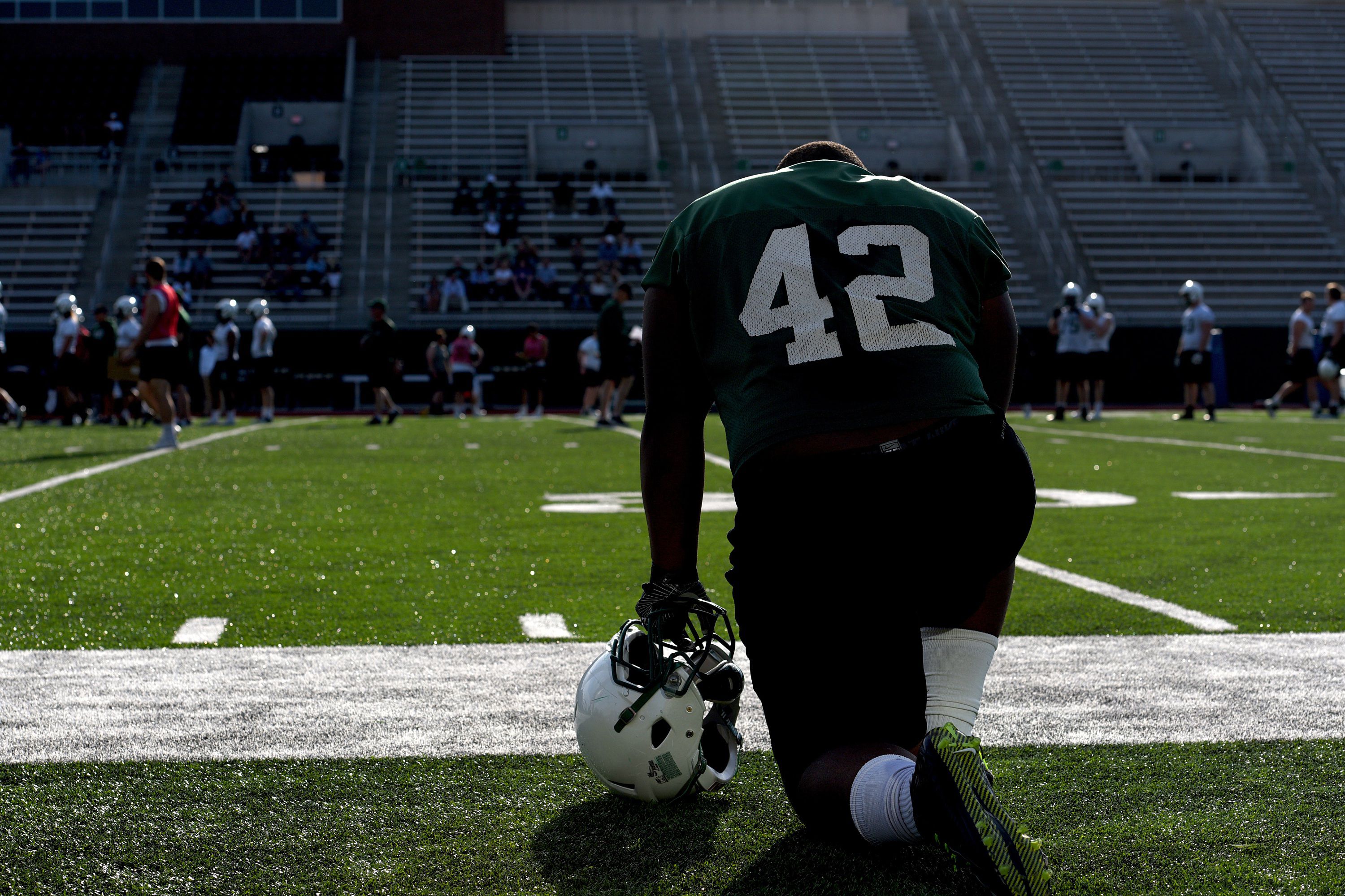 Dartmouth football player Davaron Stockman watches practice on April 28, 2017. Some players have sensors implanted in their helmets.  (Valley News - Jennifer Hauck) Copyright Valley News. May not be reprinted or used online without permission. Send requests to permission@vnews.com.
