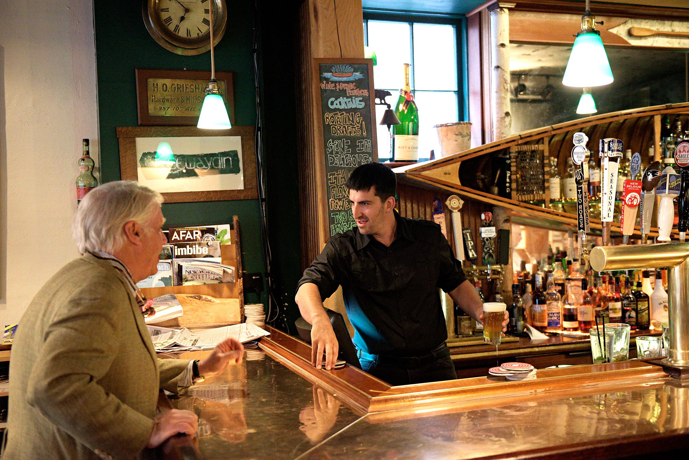 After over 13 years at the helm of the Canoe Club in Hanover, N.H., John Chapin, left, has sold the restaurant and bar to to bartender Daniel Levitt, right, who has been on staff since the establishment opened in 2003. Chapin talks with Levitt between at the bar in Hanover, N.H. Friday, July 14,2 017. (Valley News - James M. Patterson) Copyright Valley News. May not be reprinted or used online without permission. Send requests to permission@vnews.com.
