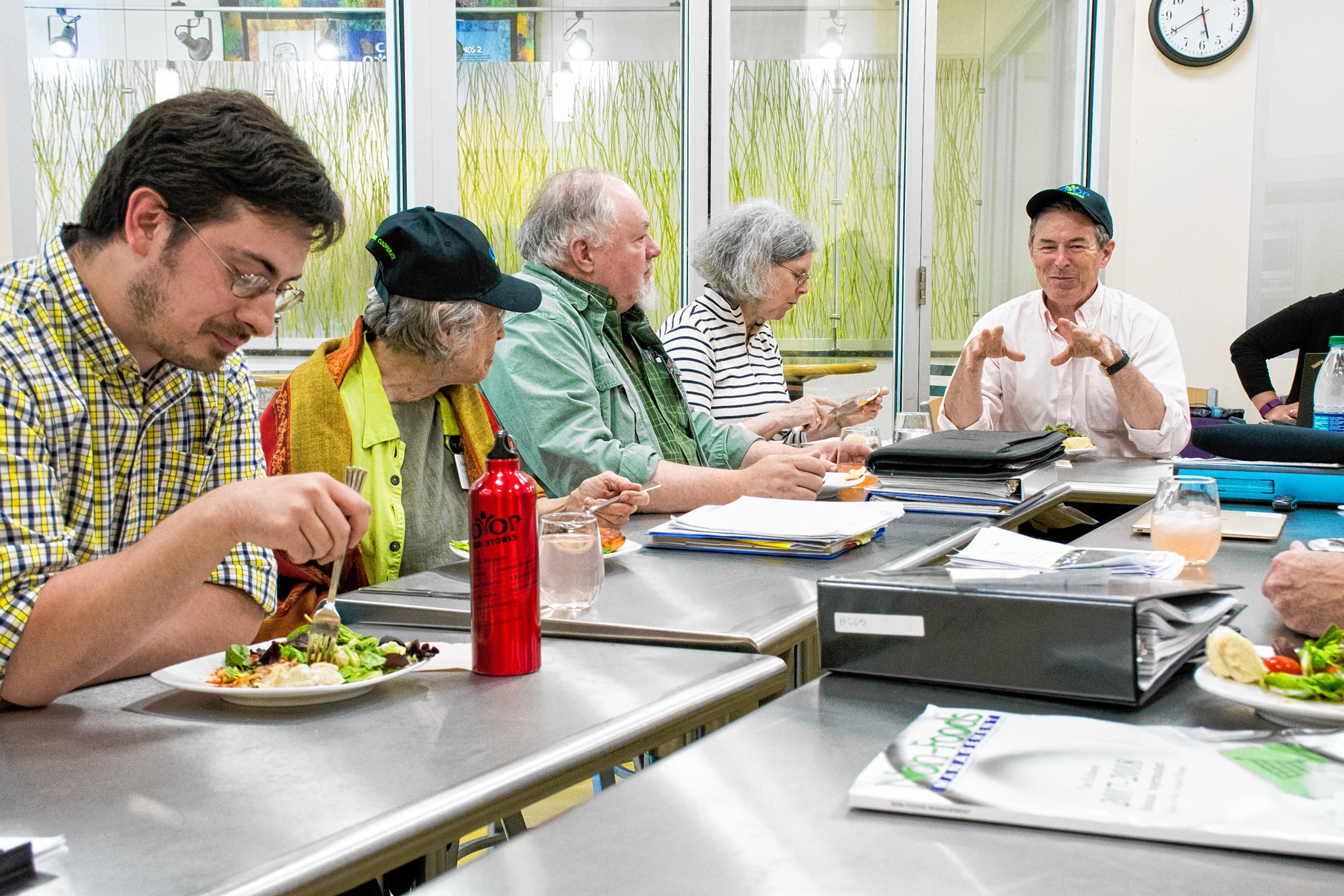 Board members enjoy a meal in the Co-Op's teaching kitchen before their board meeting. Bill Craig (far right) talks about his "glamping" adventure in Newfoundland. Nancy Nutile-McMenemy photograph.