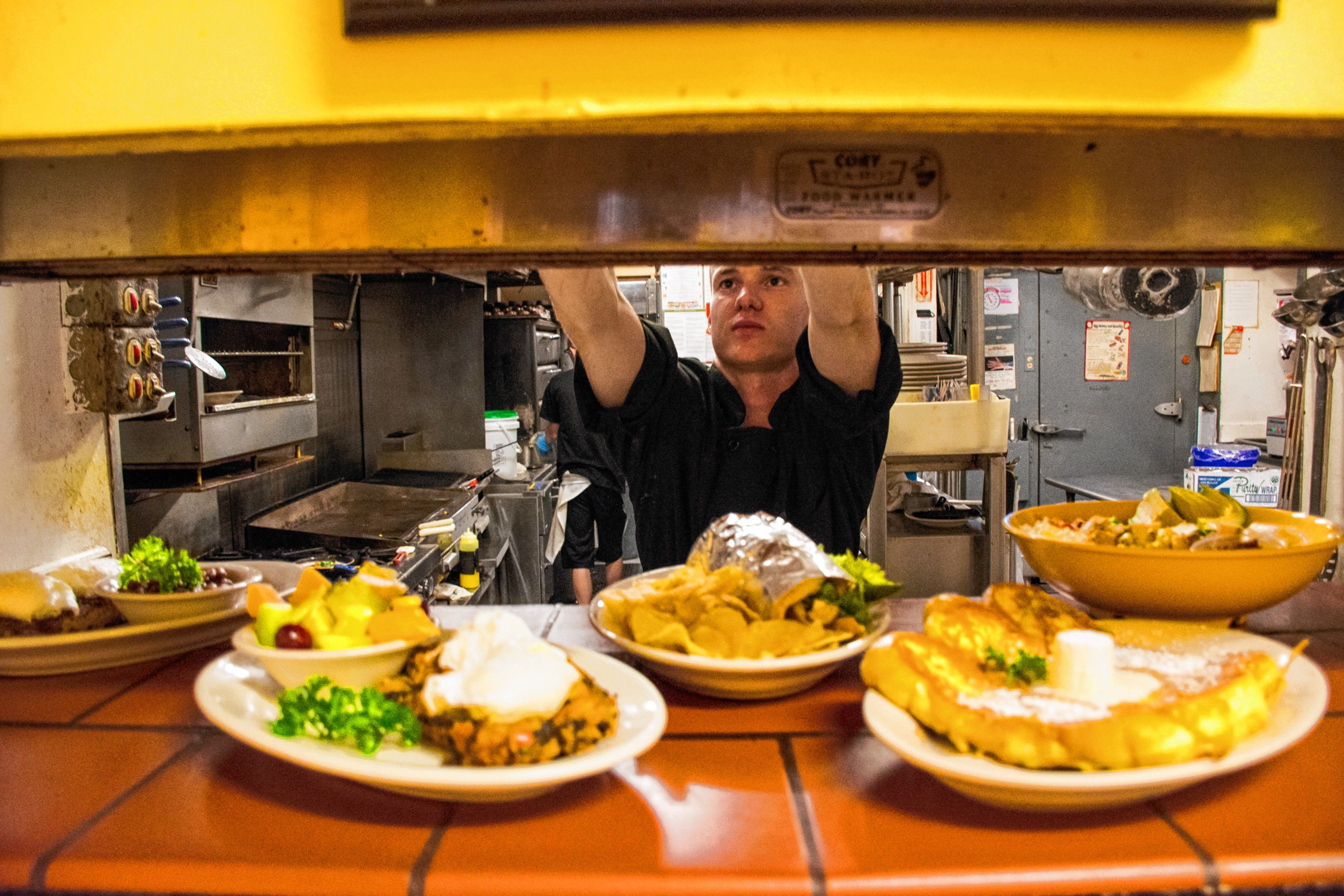 Six months into his job as chef at Lou's Restaurant and Bakery, Zach Plante Haverhill, NH plates up the last meals of the day. The kitchen closes at 3 p.m. but the bakery stays open until 5 p.m. Nancy Nutile-McMenemy photograph.