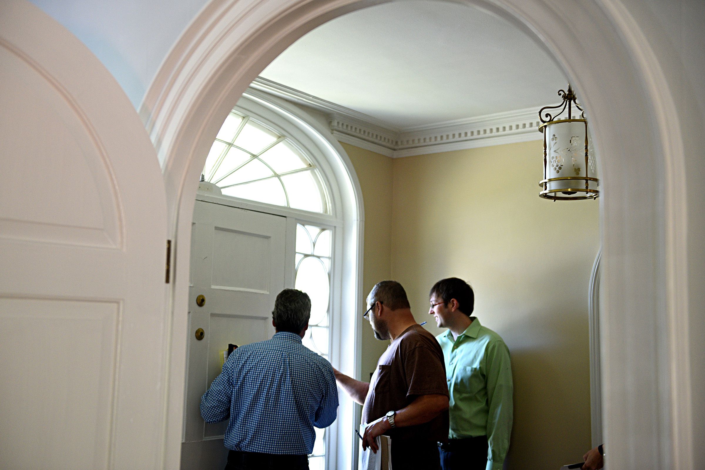 Todd Thompson vice president and project manger of Trumbull-Nelson, left, Dave Stanley superintendent at Trumbull-Nelson and Ben Van Vliet, executive director at the Upper Valley Music Center look at a crack in the glass surrounding a door in Lebanon, N.H. on Sept. 11, 2017.  (Valley News - Jennifer Hauck) Copyright Valley News. May not be reprinted or used online without permission. Send requests to permission@vnews.com.