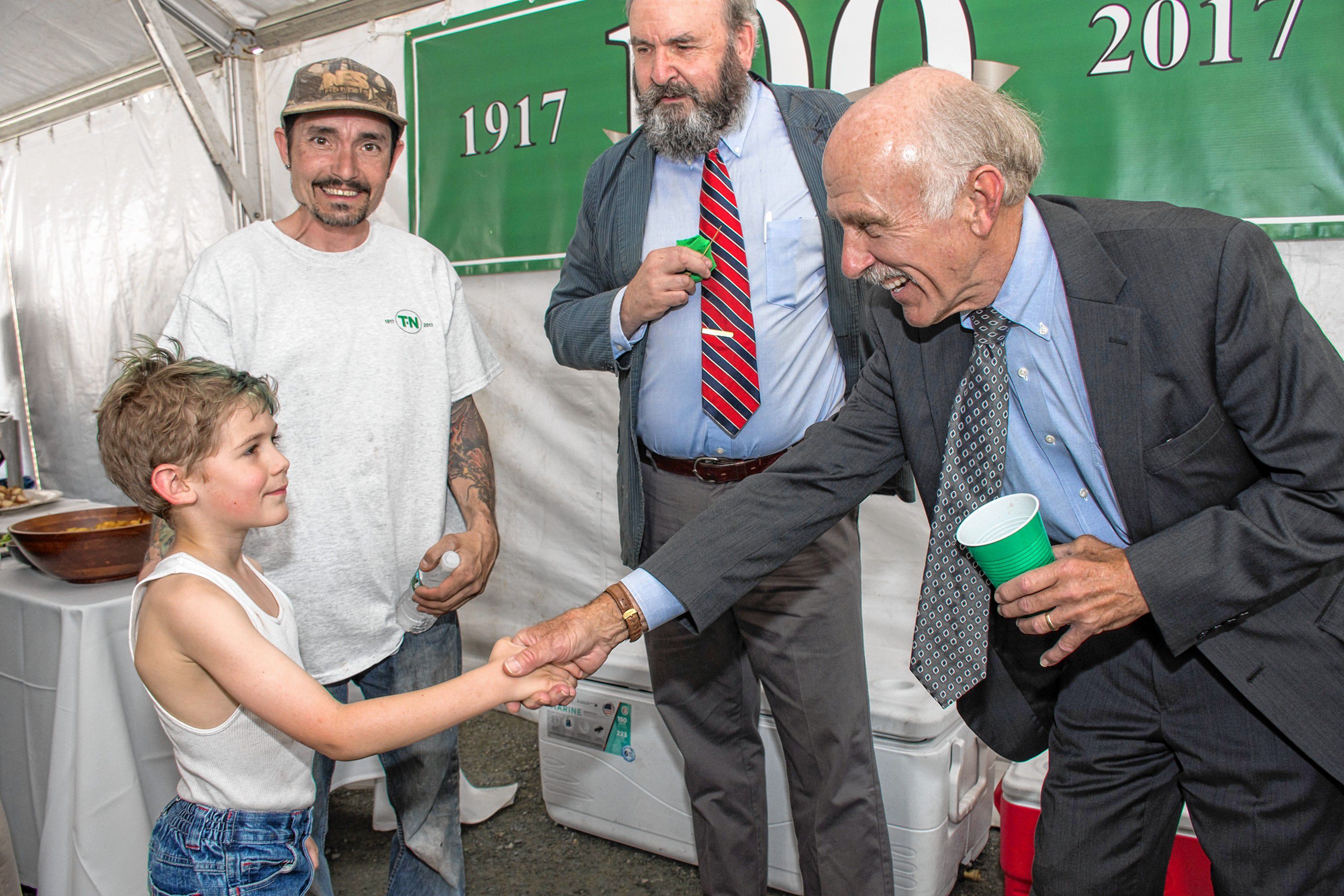 Owen Hoy, 9, shakes the hand of Trumbull-Nelson Construction Co. President Larry Ufford at the company's 100th anniversary celebration in Hanover, N.H., on May 18, 2017. Owen's father Steve Hoy has been with the company for four years. Owen Hoy told Ufford he wants to work at Trumbull-Nelson. "I want to build stuff," Hoy said. "Sign him up," Ufford said. (Nancy Nutile-McMenemy photograph)